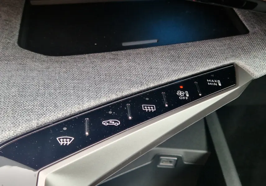 Gros plan sur les commandes de climatisation avec finition tissu gris dans l’habitacle du Peugeot 3008 gris Artense 2025.