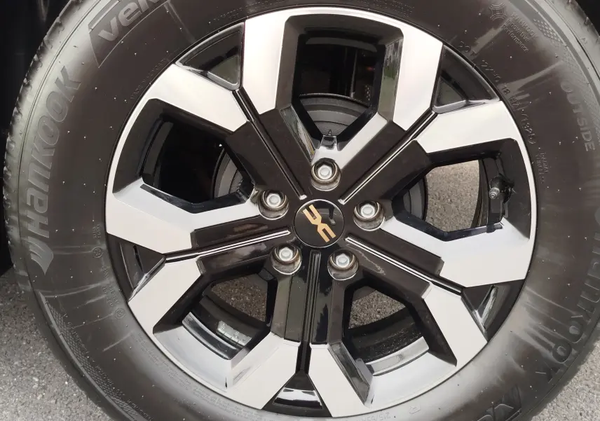 Gros plan sur la jante alliage noir et argentée du Dacia Duster 2025 gris schiste avec pneu Hankook visible.
