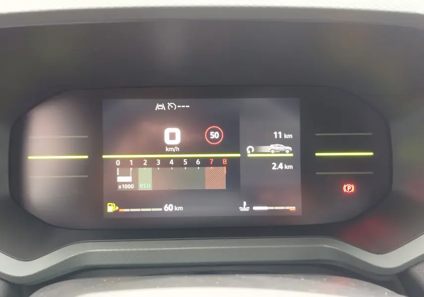 Tableau de bord numérique du Dacia Duster gris schiste 2025 affichant vitesse, régime moteur et autonomie restante.