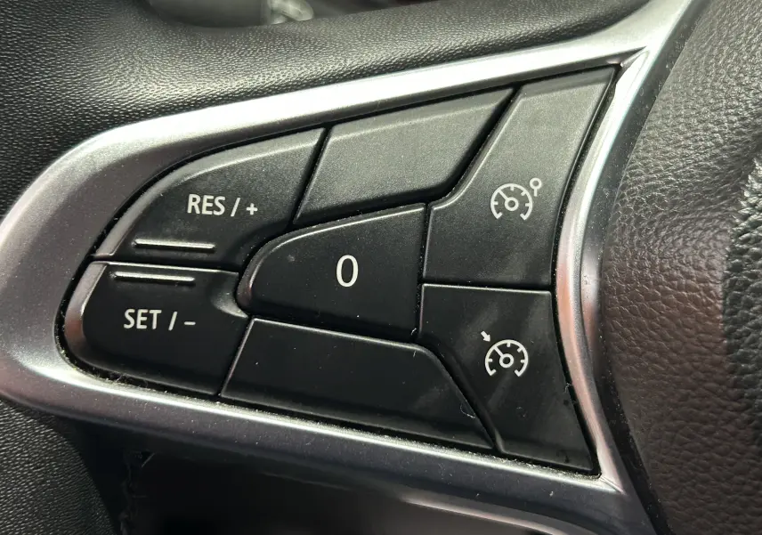 Gros plan sur les commandes de régulateur de vitesse au volant d'une Renault Clio V TCe 90 gris de 2023.