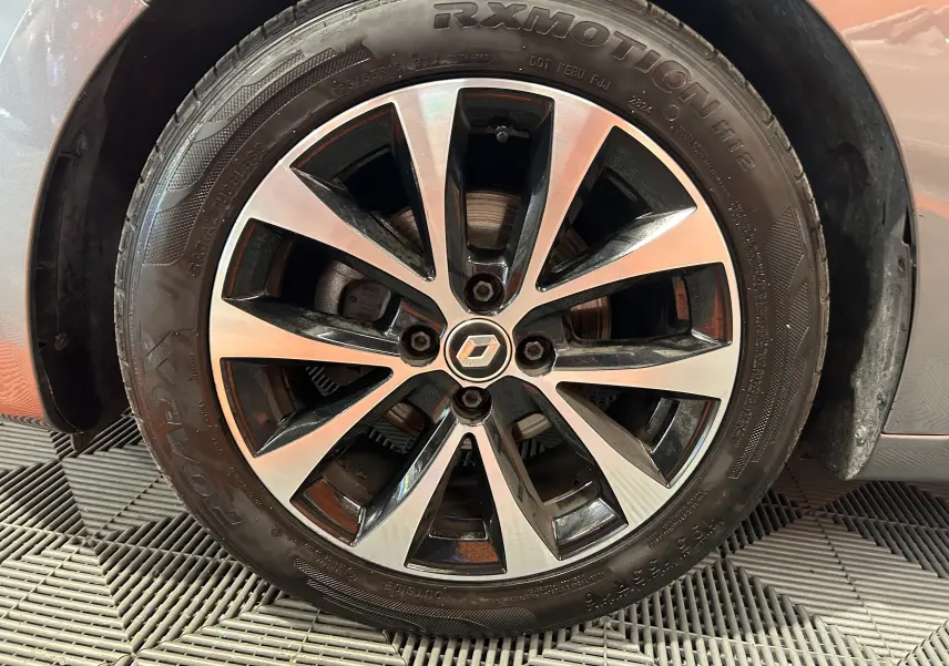 Gros plan sur la jante alliage bicolore d'une Renault Clio V gris 2023, mettant en valeur le logo central Renault.