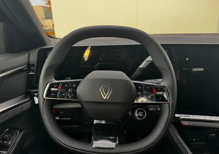 Volant rond noir avec logo Renault au centre, vue frontale du poste de conduite intérieur du Renault Espace VI hybride.