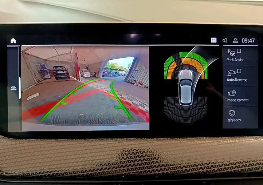 Écran multimédia de BMW Série 1 gris clair montrant la caméra de recul et l'aide au stationnement en intérieur.