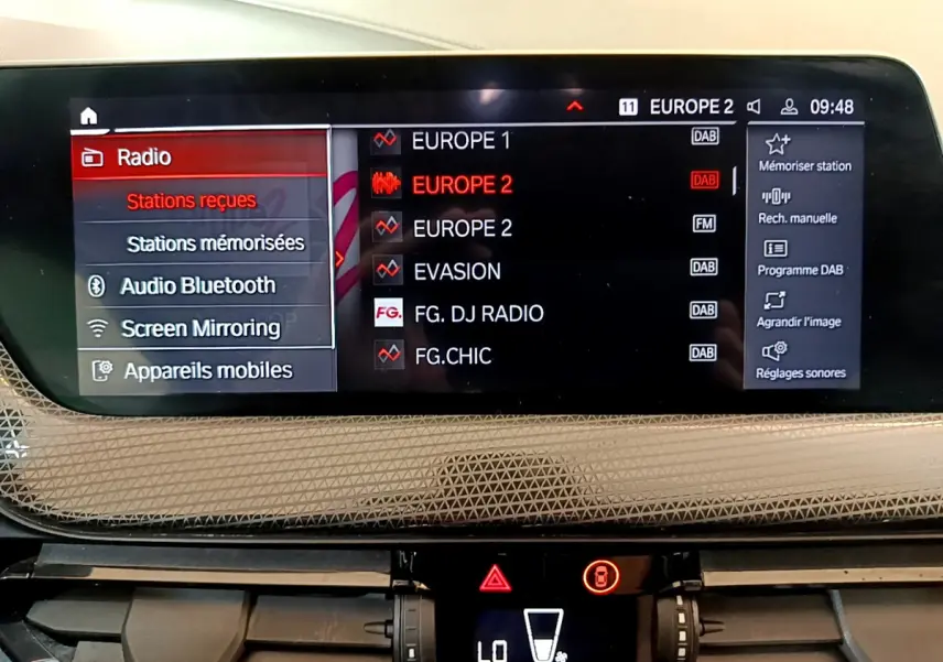 Écran central multimédia de BMW Série 1 118i 2021 affichant les stations radio et options connectées.