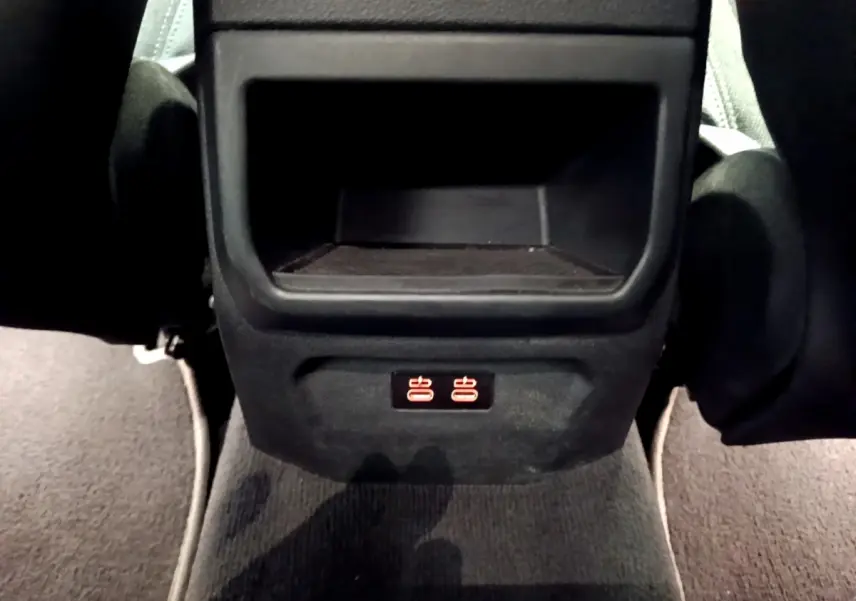 Prise USB arrière illuminée sous le rangement central des sièges arrière d'une BMW Série 1 gris clair.