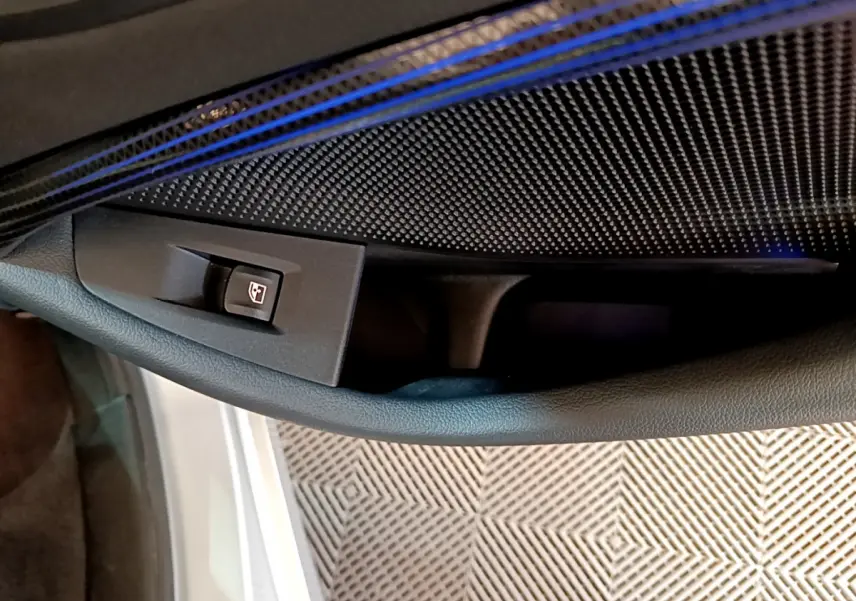 Gros plan sur la commande de lève-vitre côté gauche dans l'habitacle d'une BMW Série 1 gris clair Edition Sport 2021.