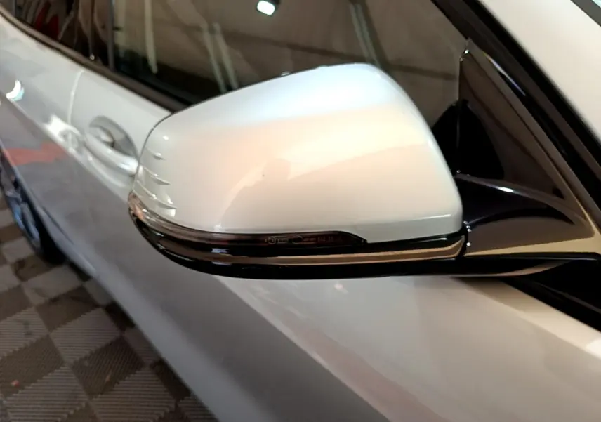 Gros plan sur le rétroviseur droit gris clair de la BMW Série 1 Edition Sport 2021 avec clignotant intégré.