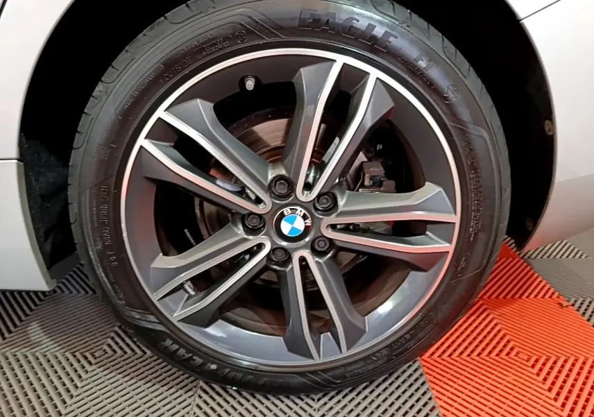 Gros plan sur la jante alliage gris foncé et le pneu Goodyear d’une BMW Série 1 gris clair, côté avant droit.