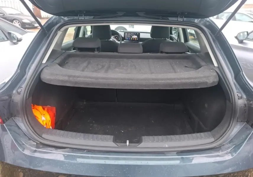 Coffre ouvert vu de l'arrière d'une SEAT LEON gris 2021, avec cache-bagages et intérieur noir visible.
