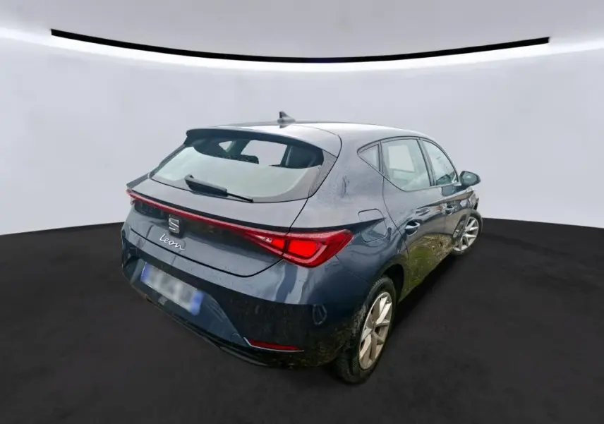 Vue 3/4 arrière droite d'une SEAT Leon gris métallisé 5 portes, avec feux arrière LED et toit avec antenne requin.