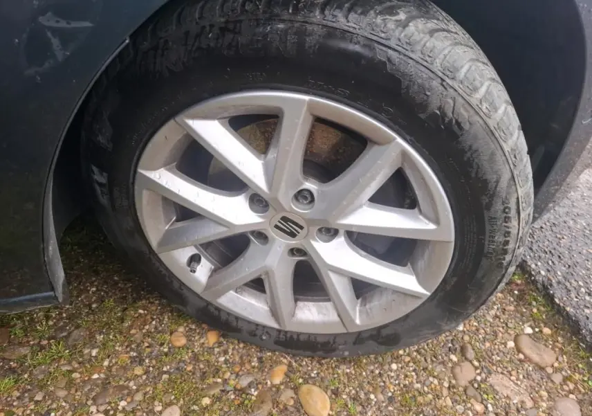 Gros plan sur la roue avant droite d'une SEAT LEON gris 2021 avec jante alliage et logo central visible.