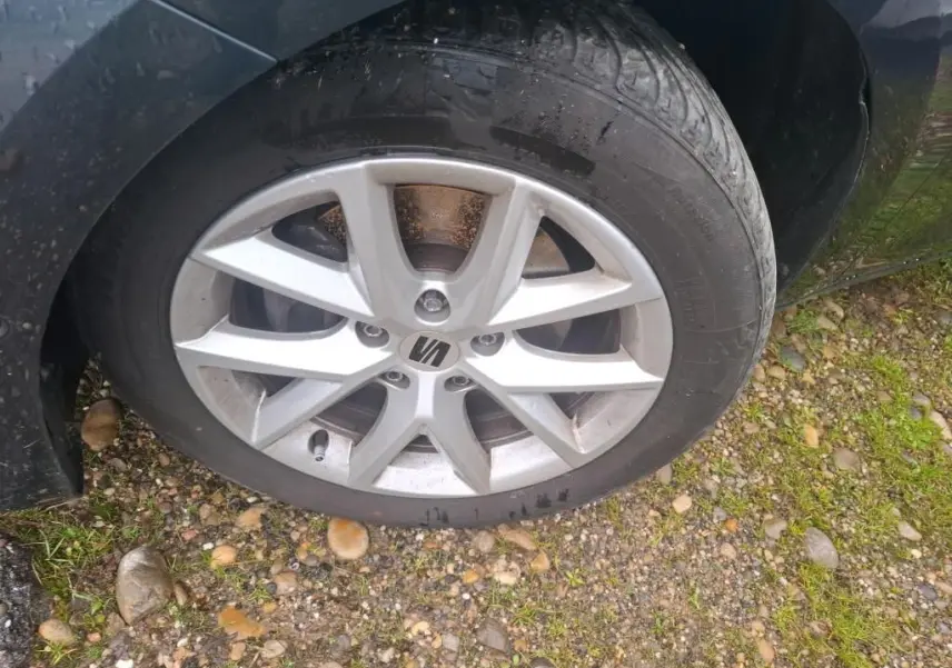 Gros plan sur la roue avant droite d'une SEAT Leon gris 2021 avec jante alliage et logo central visible.