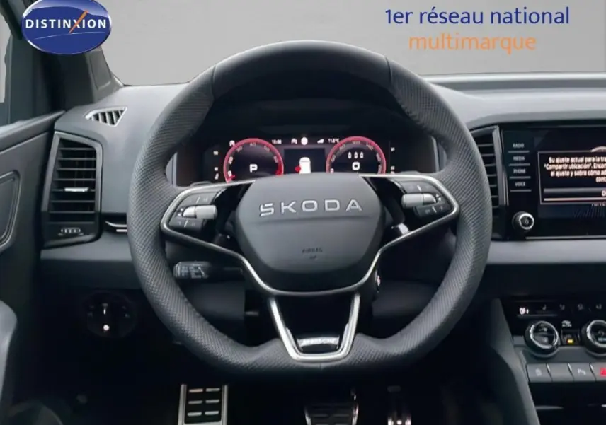 Vue intérieure centrée sur le volant cuir SKODA KAROQ 1.5 TSI 150CH DSG7 SPORTLINE avec écran digital et commandes intégrées.