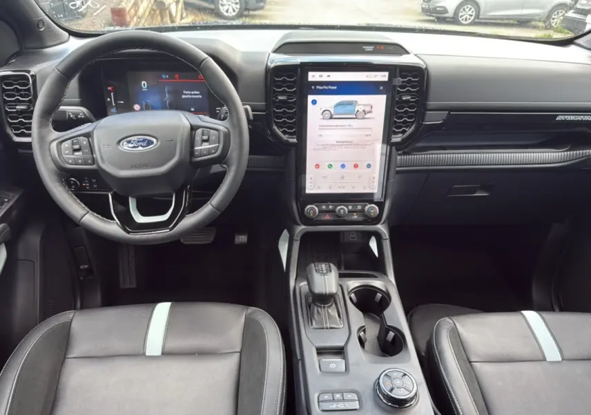 Vue intérieure avant du Ford Ranger 2.3 PHEV noir agate, volant cuir multifonctions et écran tactile vertical central.