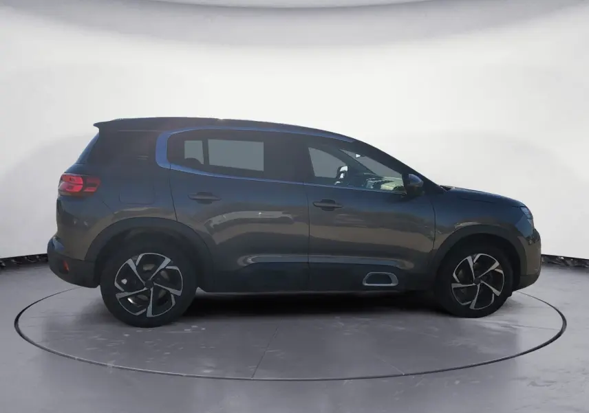 Vue de profil côté gauche d'un Citroën C5 Aircross gris platinium avec jantes bi-ton et protections noires.