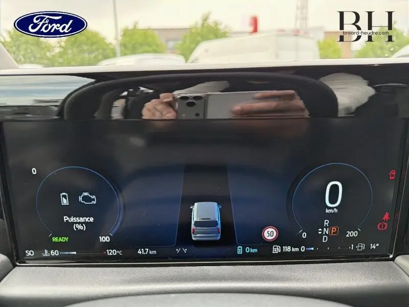 Tableau de bord numérique du Ford Transit Custom gris, affichant la vitesse à 0 km/h et l’état hybride.