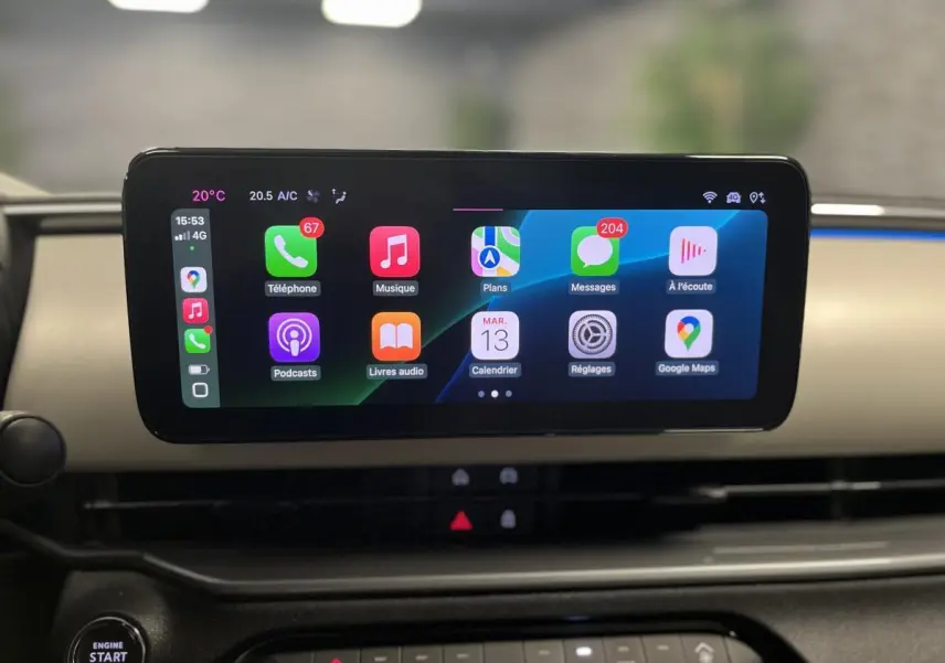 Écran tactile central affichant Apple CarPlay dans l'habitacle ivoire du Fiat 600 hybride noir 2024.