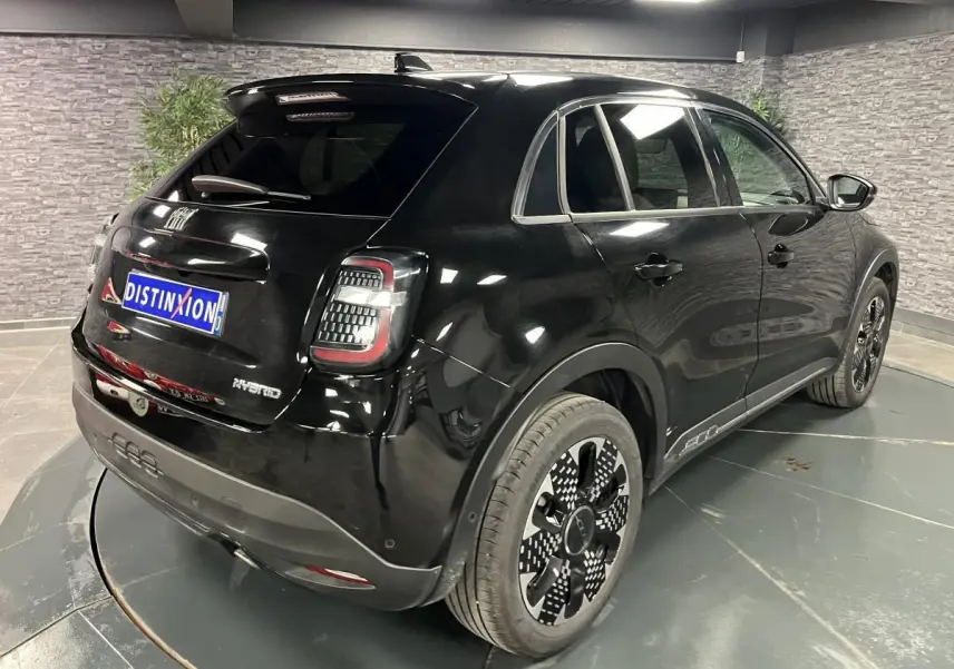 Vue 3/4 arrière droite de la FIAT 600 noire hybride 2024 avec jantes alliage et feux arrière LED distinctifs.