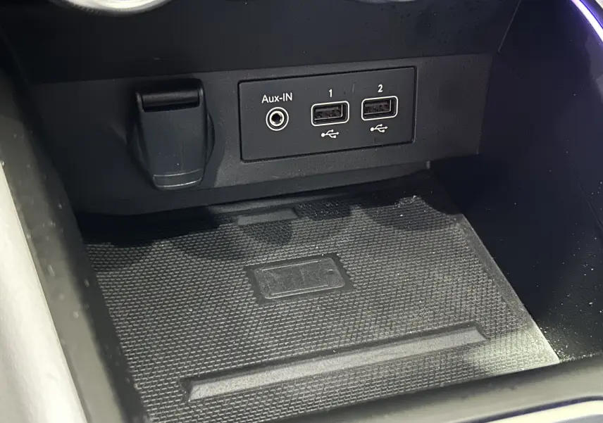 Gros plan sur la console centrale de la Renault Clio V rouge 2023, montrant les ports USB et prise Aux-IN.