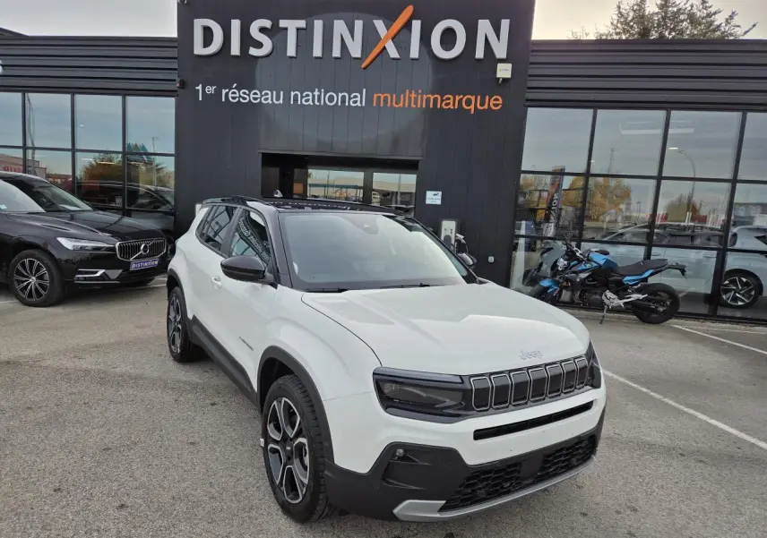 Jeep Avenger blanc Snow avec toit noir Volcano, vue 3/4 avant, calandre gloss black et jantes alliage 18 pouces.