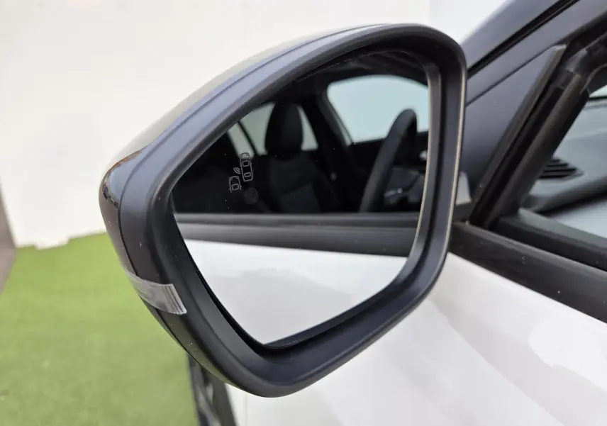 Rétroviseur extérieur côté gauche noir brillant sur Jeep Avenger Snow avec intérieur visible en arrière-plan.