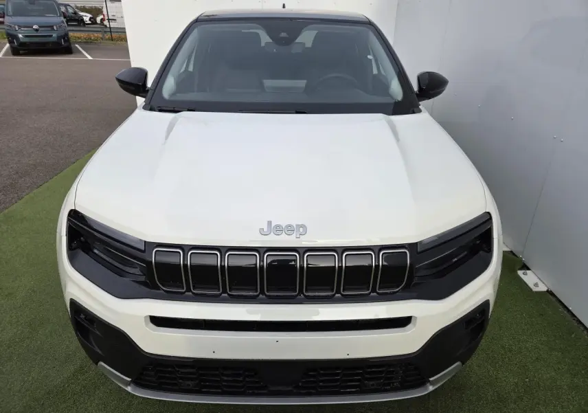 Vue avant d'un Jeep Avenger 2025 blanc Snow avec calandre gloss black et toit Volcano noir.