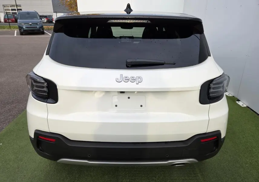 Vue arrière d'un Jeep Avenger 2025 blanc Snow avec toit noir Volcano et feux arrière LED fumés.