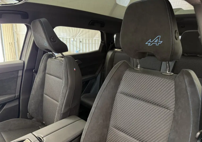 Vue intérieure côté droit des sièges avant en suède gris foncé avec logo Alpine bleu sur appuie-tête du Renault Espace 2025 esprit Alpine.