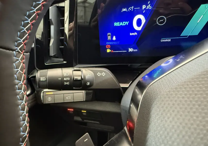 Gros plan sur le combiné d'instruments numérique bleu et la commande des phares du Renault Espace gris foncé esprit Alpine 2025.