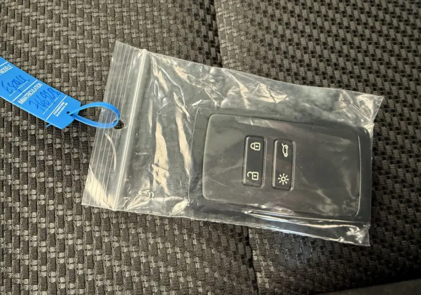 Télécommande noire Renault Espace esprit Alpine 2025 dans sachet plastique sur siège tissu gris foncé