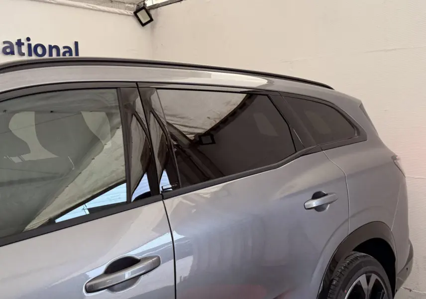 Vue latérale droite du Renault Espace gris foncé esprit Alpine 7 places, mettant en valeur ses vitres teintées et poignées de porte intégrées.