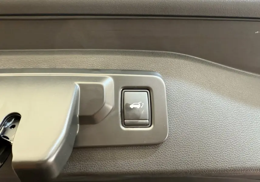 Bouton d'ouverture électrique du coffre sur la garniture intérieure du Renault Espace gris foncé esprit Alpine 2025.