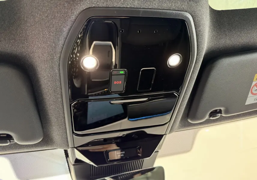 Vue en contre-plongée du plafonnier noir brillant avec bouton SOS et éclairages dans un Renault Espace gris foncé 2025 esprit Alpine.