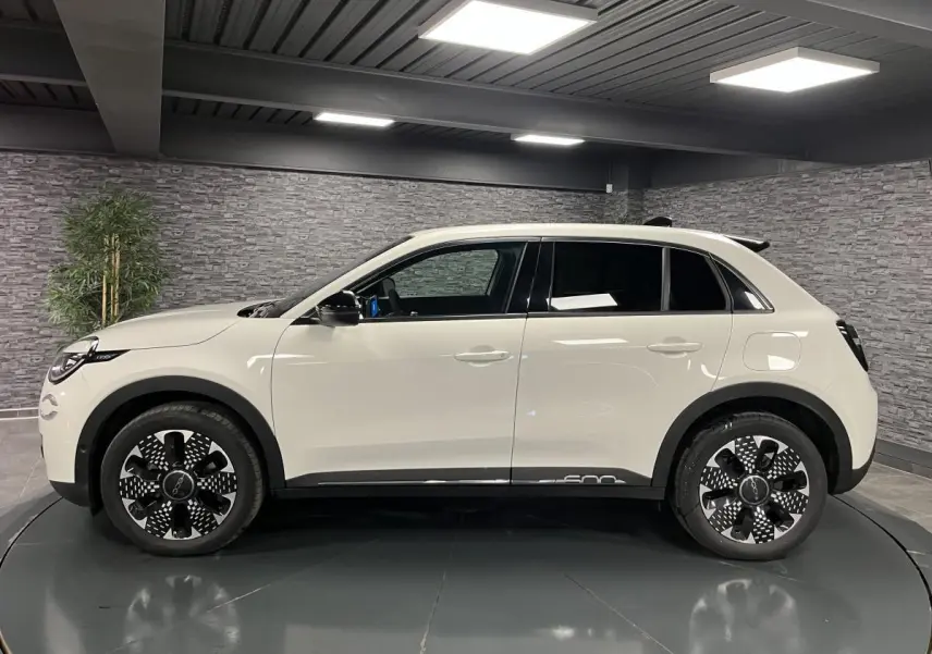 Profil côté gauche d'une FIAT 600 blanche 2024 avec jantes alliage diamantées et vitres arrière surteintées.