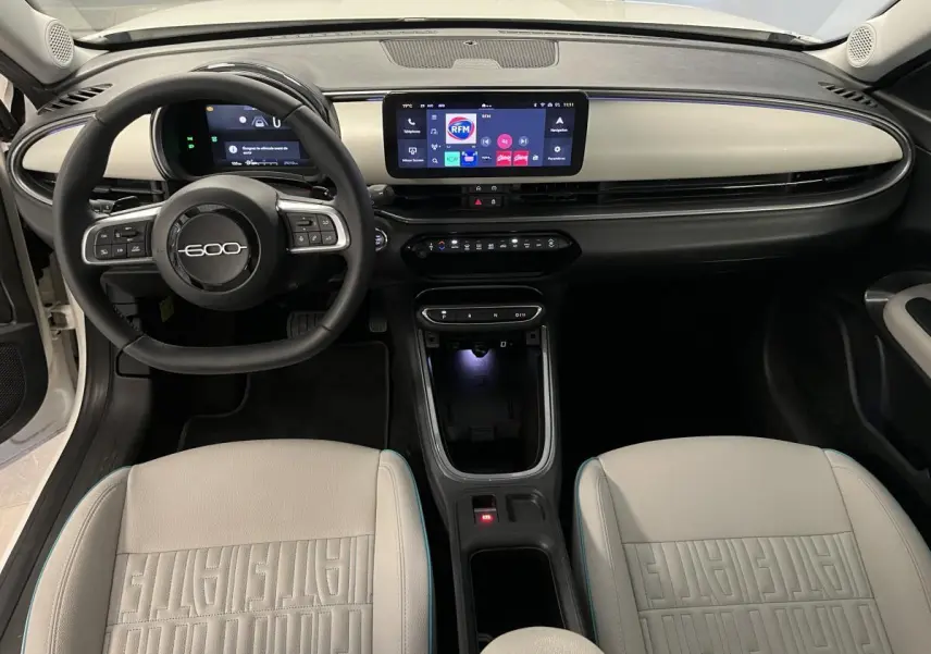 Vue intérieure avant du tableau de bord ivoire et volant noir marqué 600, sièges ivoire avec monogrammes FIAT visibles.