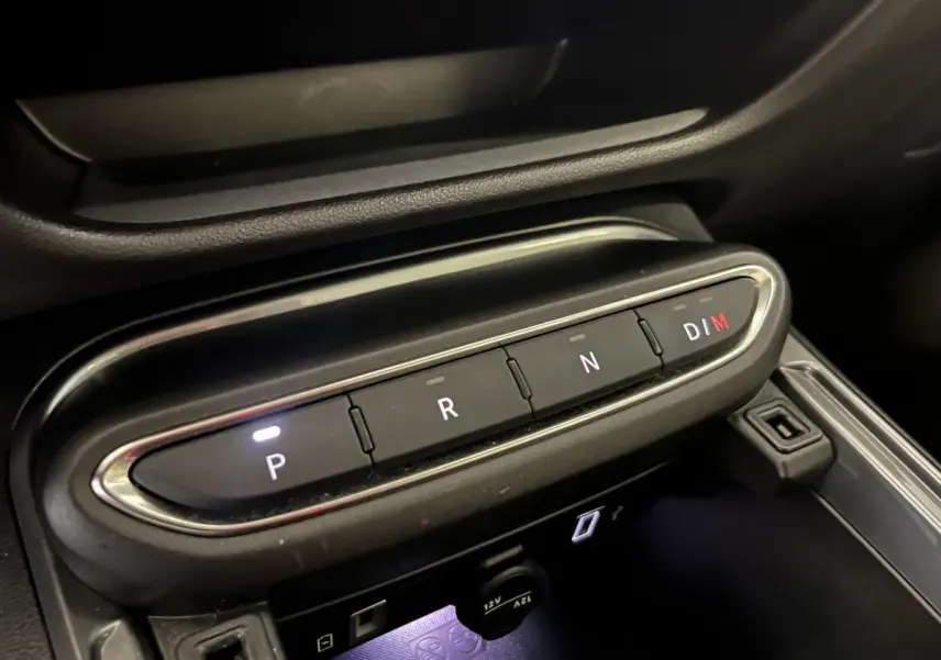 Gros plan sur la console centrale de la FIAT 600 blanche 2024, montrant les boutons de la boîte auto et prise 12V.