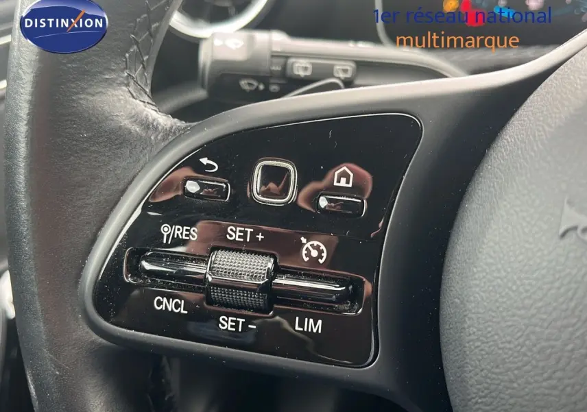 Gros plan sur les commandes de régulateur de vitesse au volant cuir noir d’une Mercedes CLA Shooting Brake argent iridium.