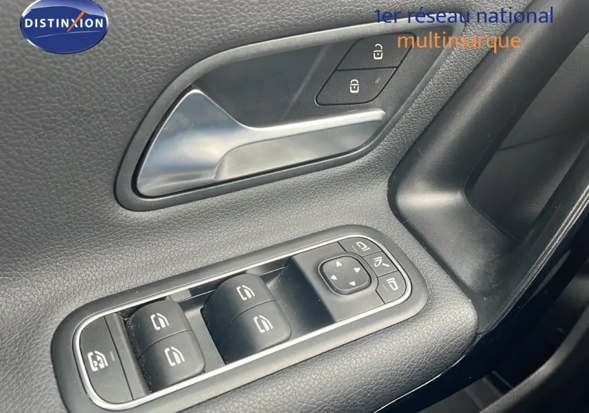 Gros plan sur la commande des vitres et la poignée intérieure côté conducteur d'une Mercedes CLA Shooting Brake argent iridium.