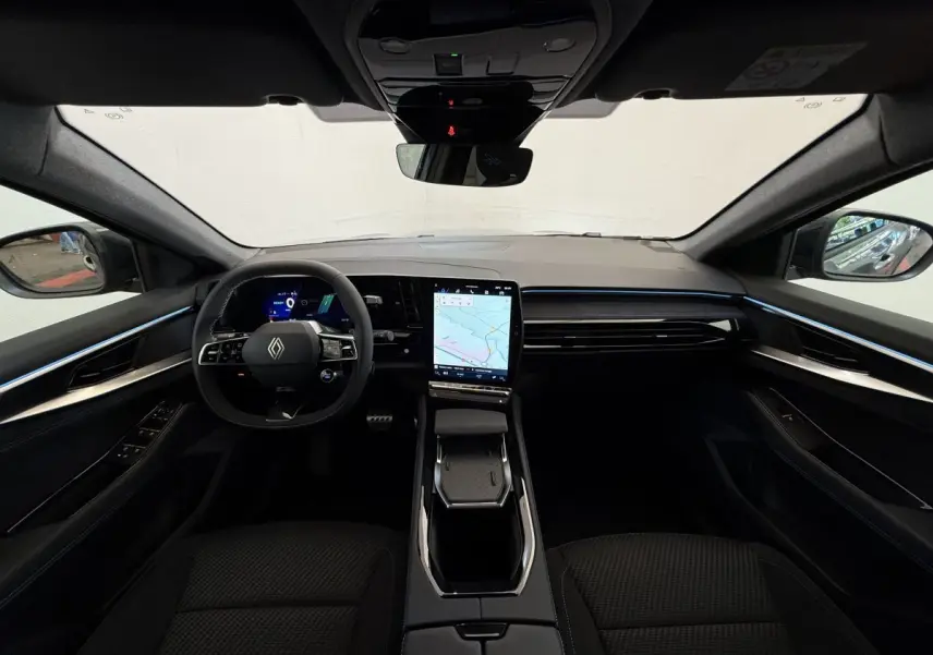 Vue intérieure avant du Renault Espace esprit Alpine 2025, tableau de bord moderne avec écran tactile vertical et ambiance lumineuse bleue.