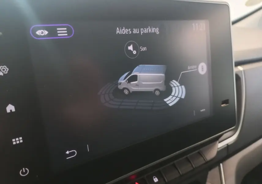 Écran tactile intérieur montrant l’aide au parking du Renault Trafic Fourgon blanc, vue de profil côté droit.