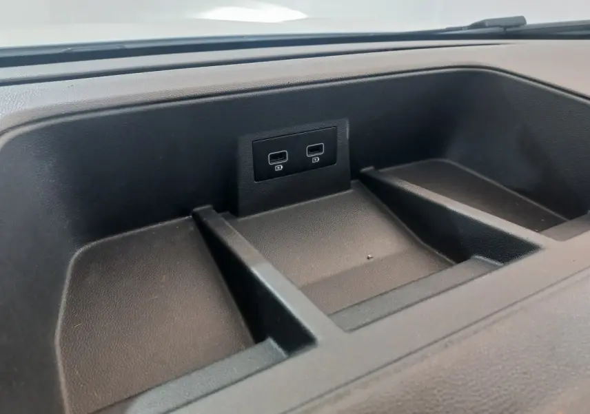 Gros plan sur le rangement noir du tableau de bord avec deux ports USB du Renault Trafic Fourgon blanc 2022.