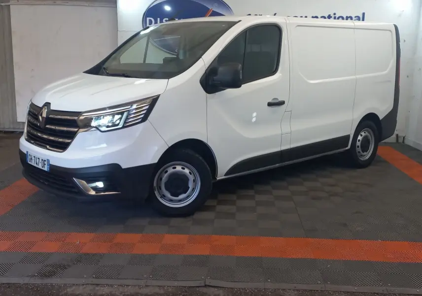 Renault Trafic Fourgon blanc vu de 3/4 avant droit, avec phares LED allumés et jantes acier grises.