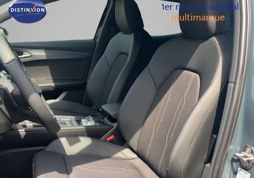 Vue intérieure côté conducteur de la CUPRA Formentor 1.5 eTSI 150CH DSG7 avec sièges en cuir et tissu noir, porte ouverte.