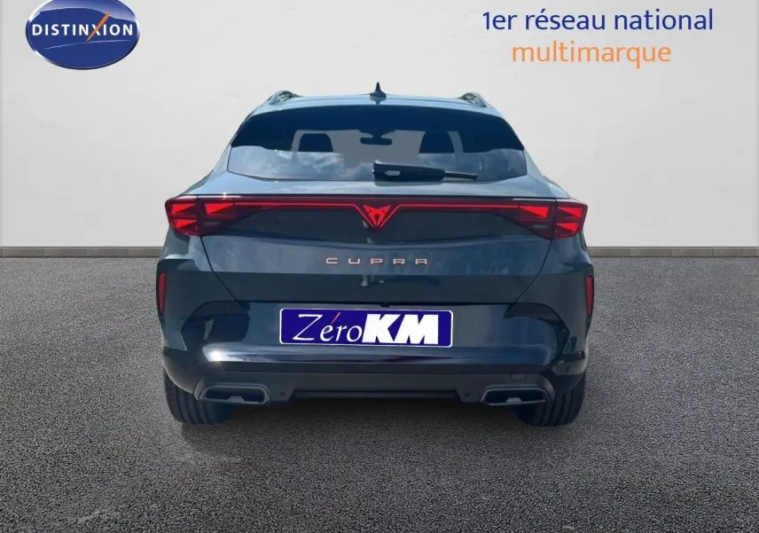 Vue arrière d'une CUPRA Formentor bleu Fjord Métal avec feux arrière reliés et double sortie d'échappement intégrée.