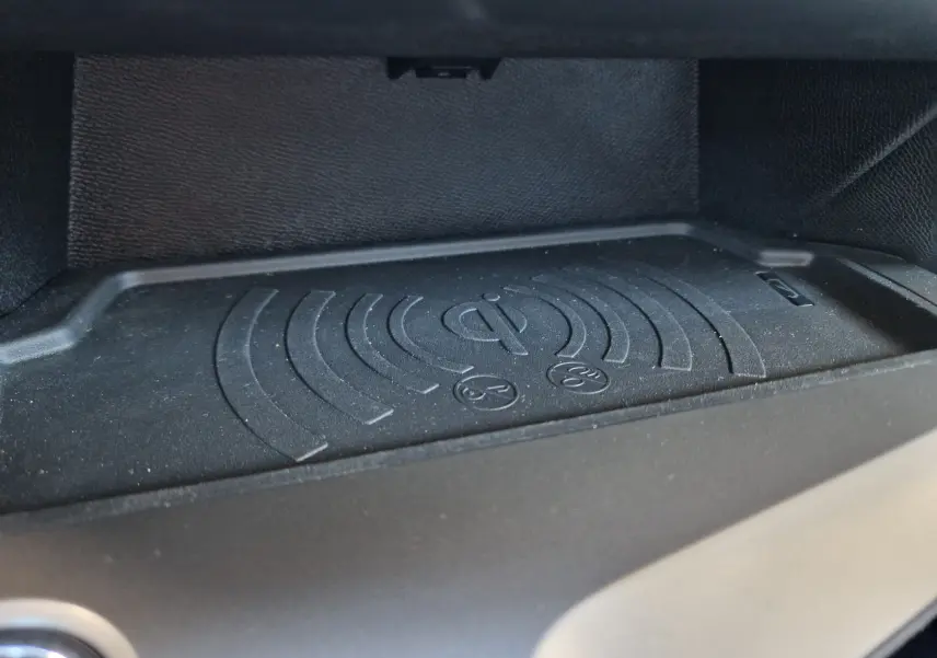 Gros plan sur le chargeur sans fil intégré dans l'habitacle de la Peugeot 308 gris Artense, version 2025.