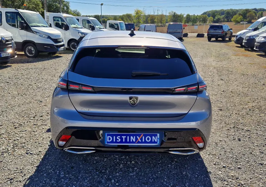 Vue arrière d'une Peugeot 308 gris Artense 2025 avec feux LED étirés et double sortie d'échappement chromée.