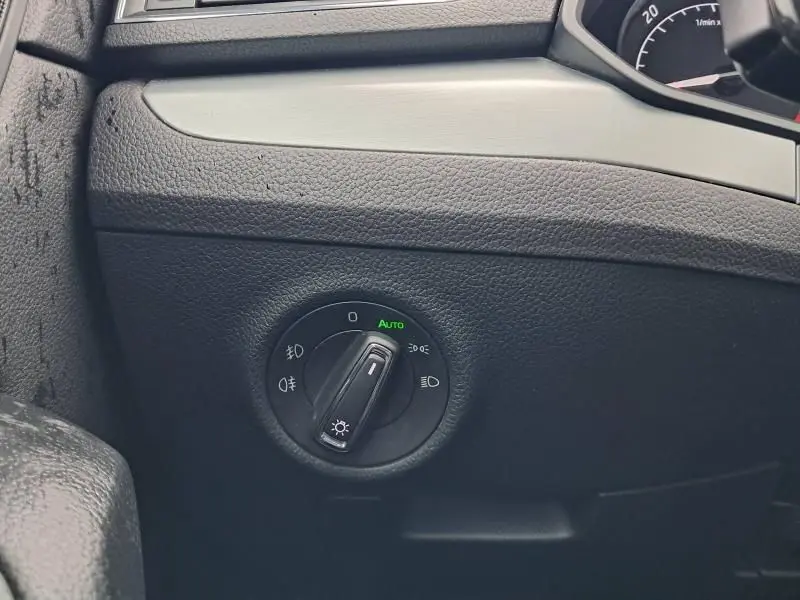 Gros plan sur le bouton de commande des phares en mode automatique dans l'habitacle d'une Skoda Superb Combi bleu métal 2018.