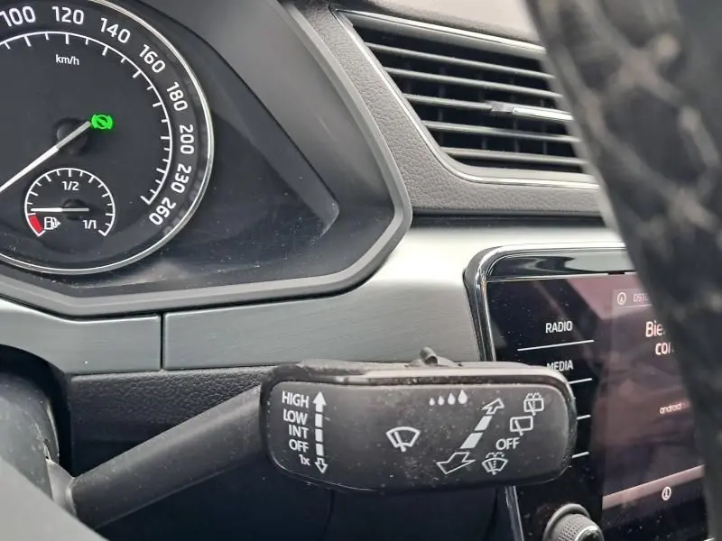 Gros plan sur le commodo d'essuie-glace côté gauche du tableau de bord d'une Skoda Superb Combi bleu métal de 2018.