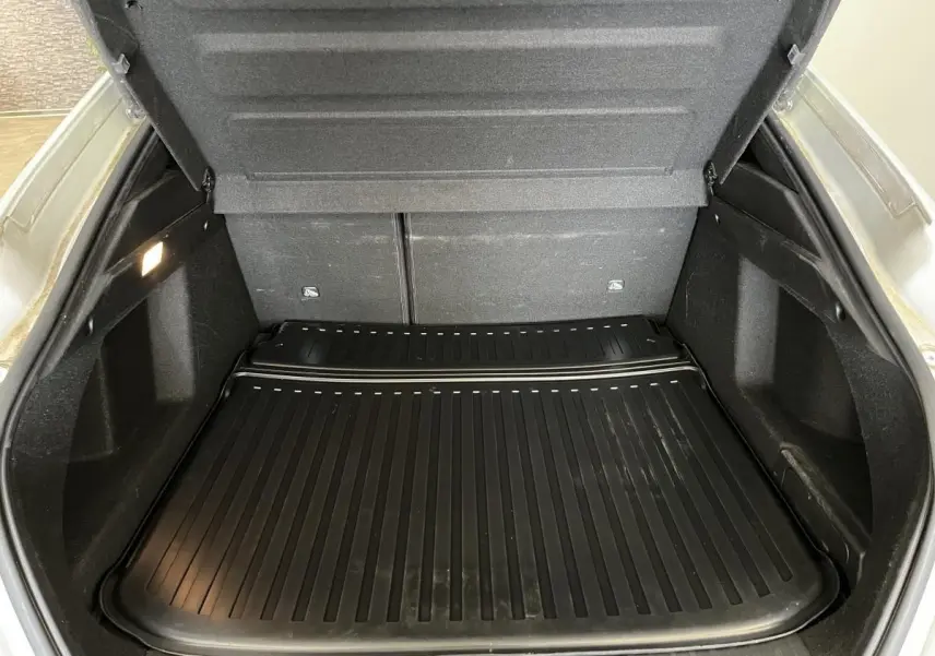 Coffre ouvert d'une Renault Arkana blanc perle, vue arrière montrant le tapis de protection noir et les parois intérieures.