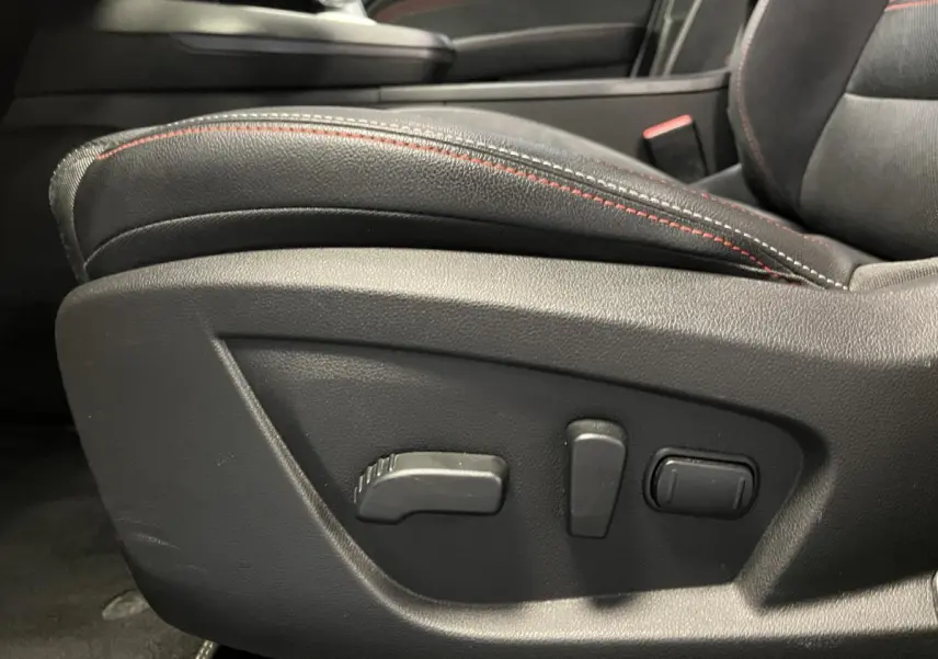 Détail des commandes de réglage électrique du siège avant droit noir avec surpiqûres rouges dans Renault Arkana R.S. Line.